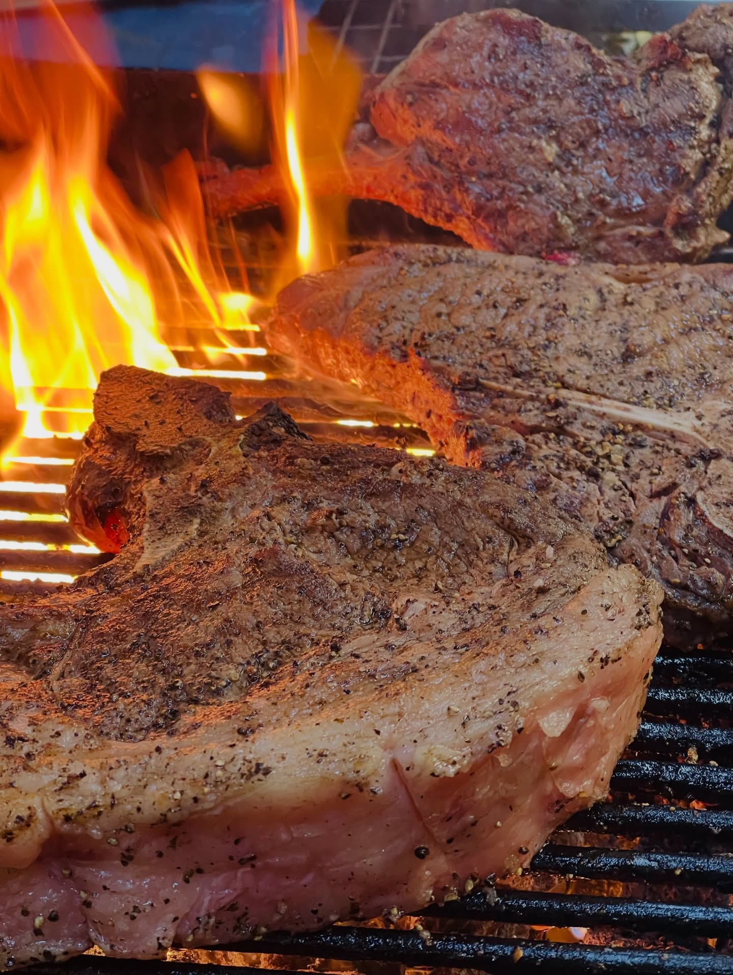 Flame-grilled prime T-bone and ribeye steaks