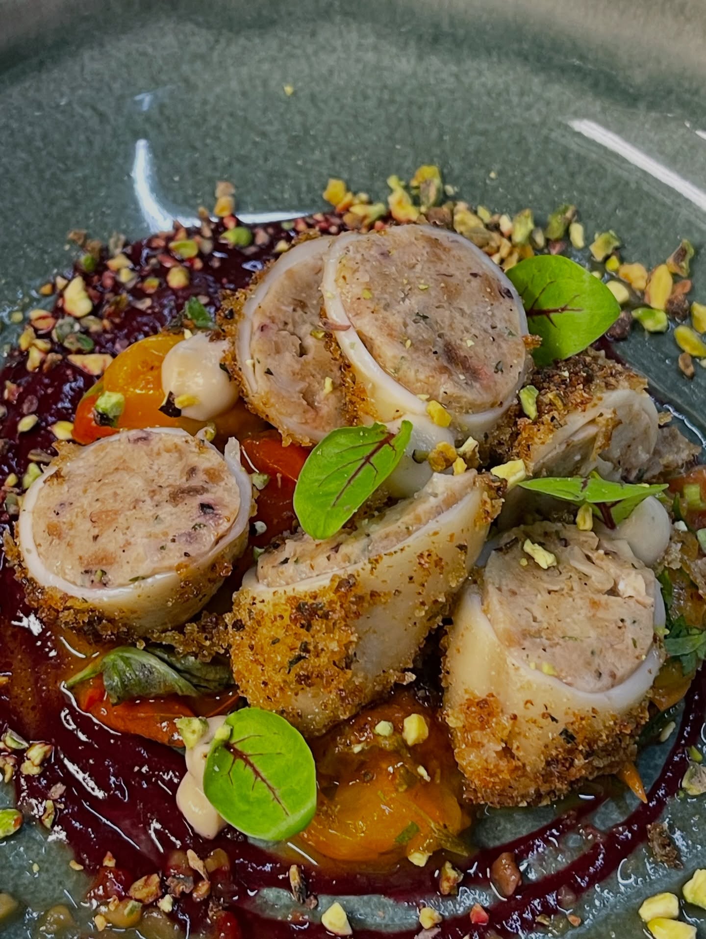 Chef's signature stuffed calamari with berry reduction and crushed pistachios