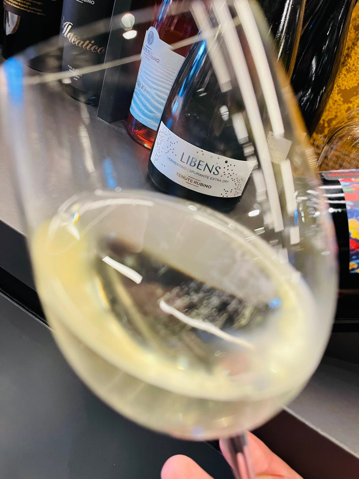 A glass of chilled white wine poured beside bottles at Meraki Wine & Dine in Rabat