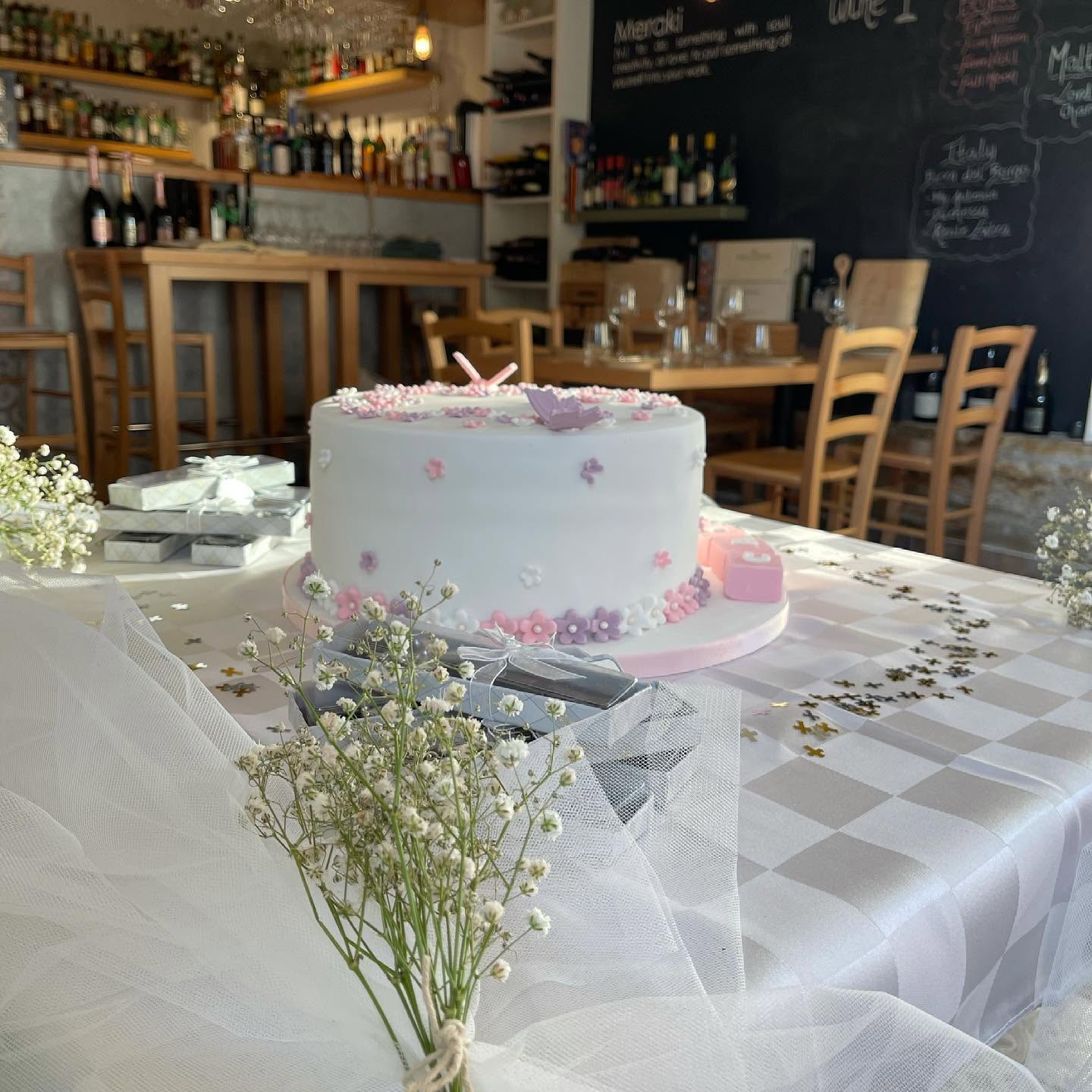Celebration cake with flower decorations on a festive table at Meraki's wine bar in Rabat